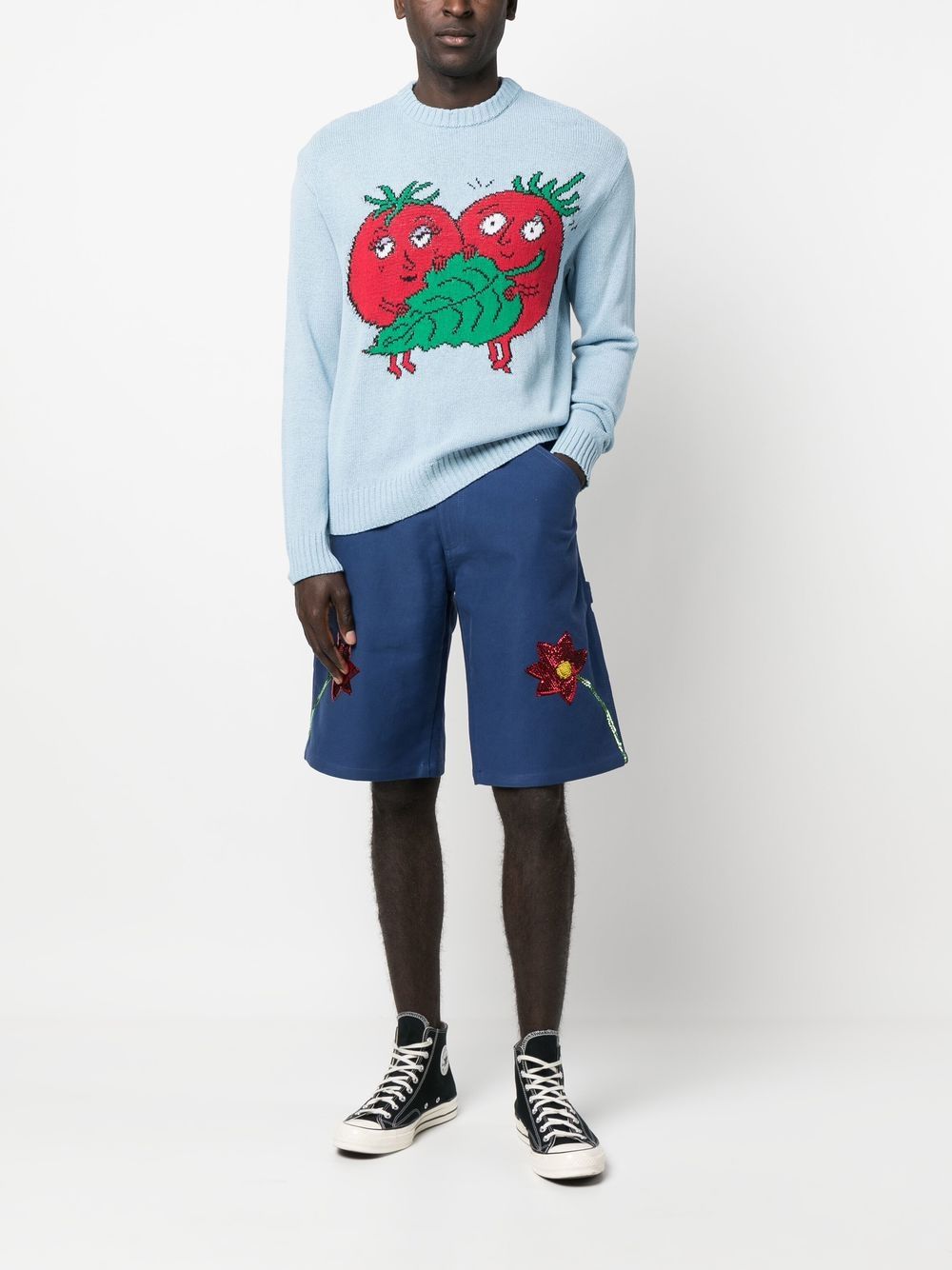 Volledige look met de blauwe short bij een lichtblauwe trui met tomatenmotief