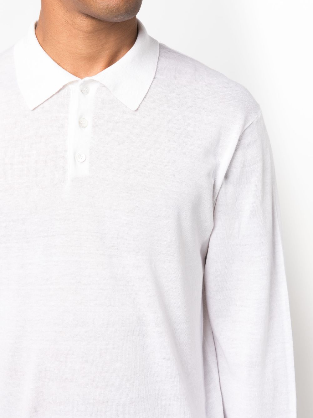 Close-up van de zachte witte kraag en de placket met drie tonale knopen