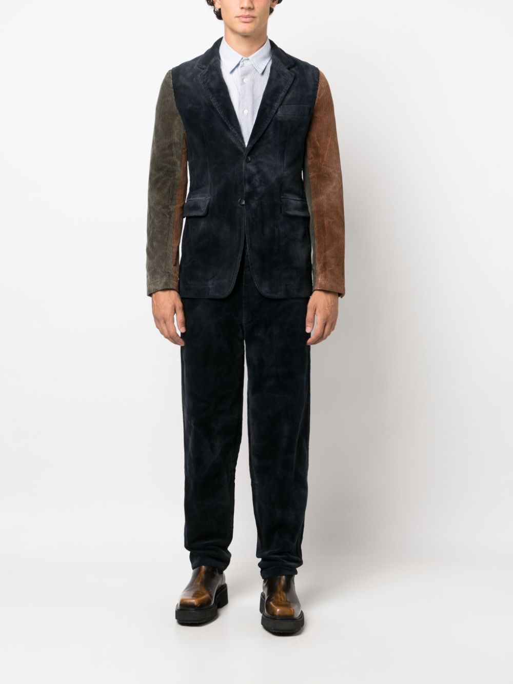 Model draagt de ribfluwelen broek met een bijpassend colbert van hetzelfde ribfluweel