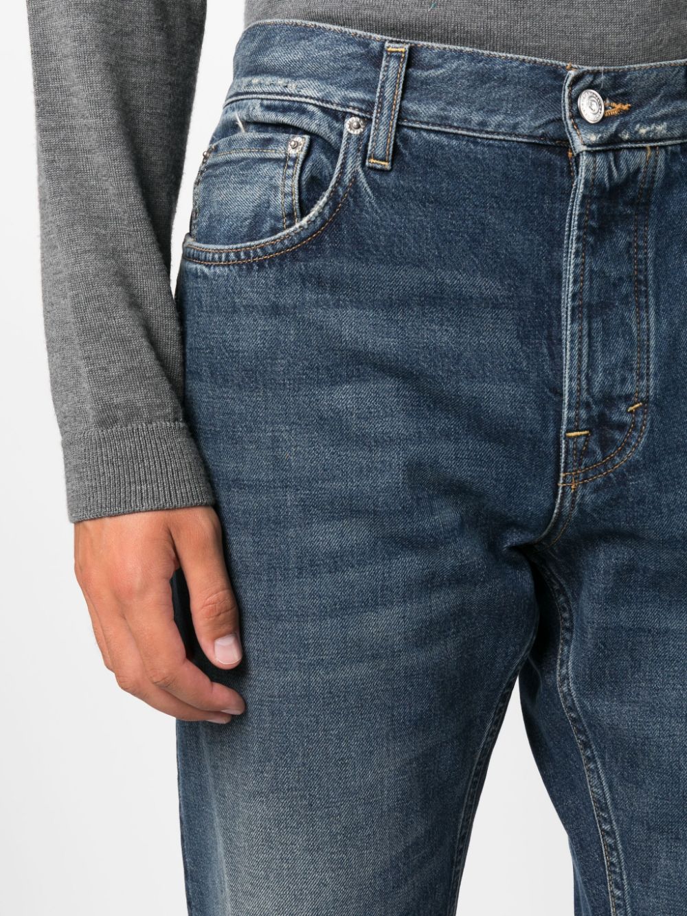 Detail van de knoopgulp en de voorzak, gedragen door een model