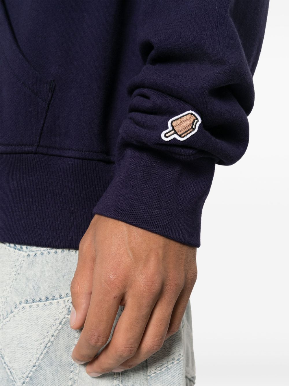 Detail van de geribde manchet met een klein geborduurd ijsje op de mouw