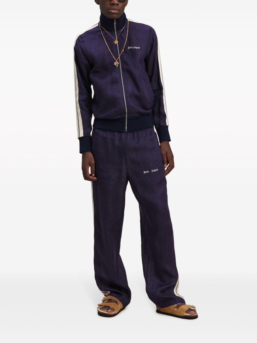 Model draagt het marineblauwe Palm Angels track jacket met bijpassende broek