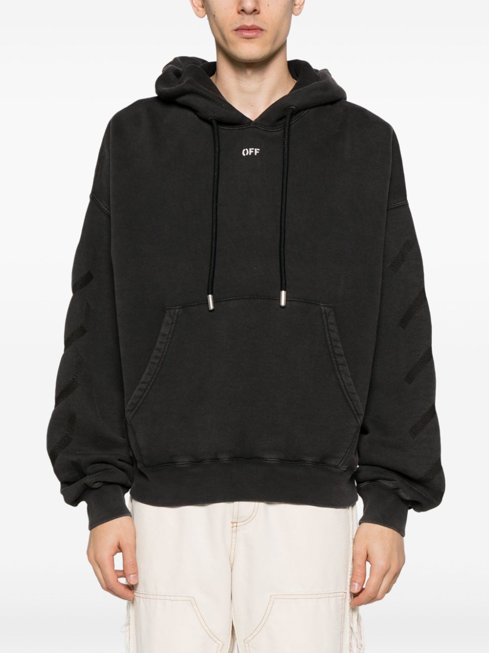 Model draagt de zwarte Off-White hoodie bij een ecru cargobroek