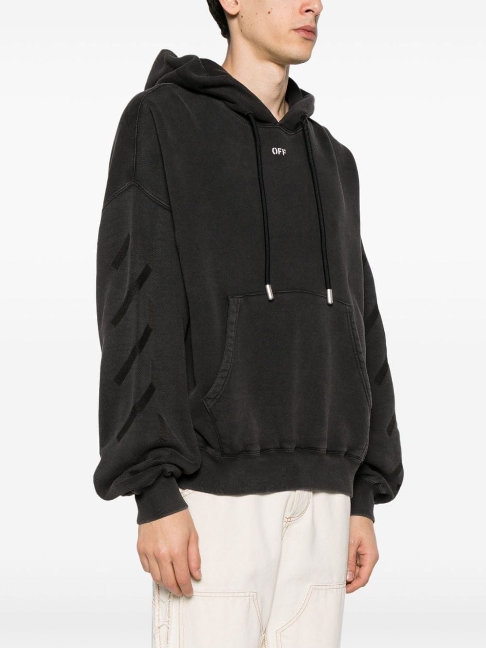 Zijaanzicht van de hoodie met de diagonale pijlen in reliëf op de mouw