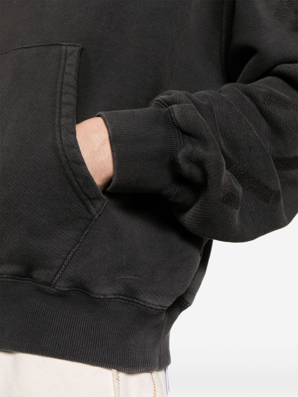 Detail van de geribde manchet en de verwassen zwarte sweatstof