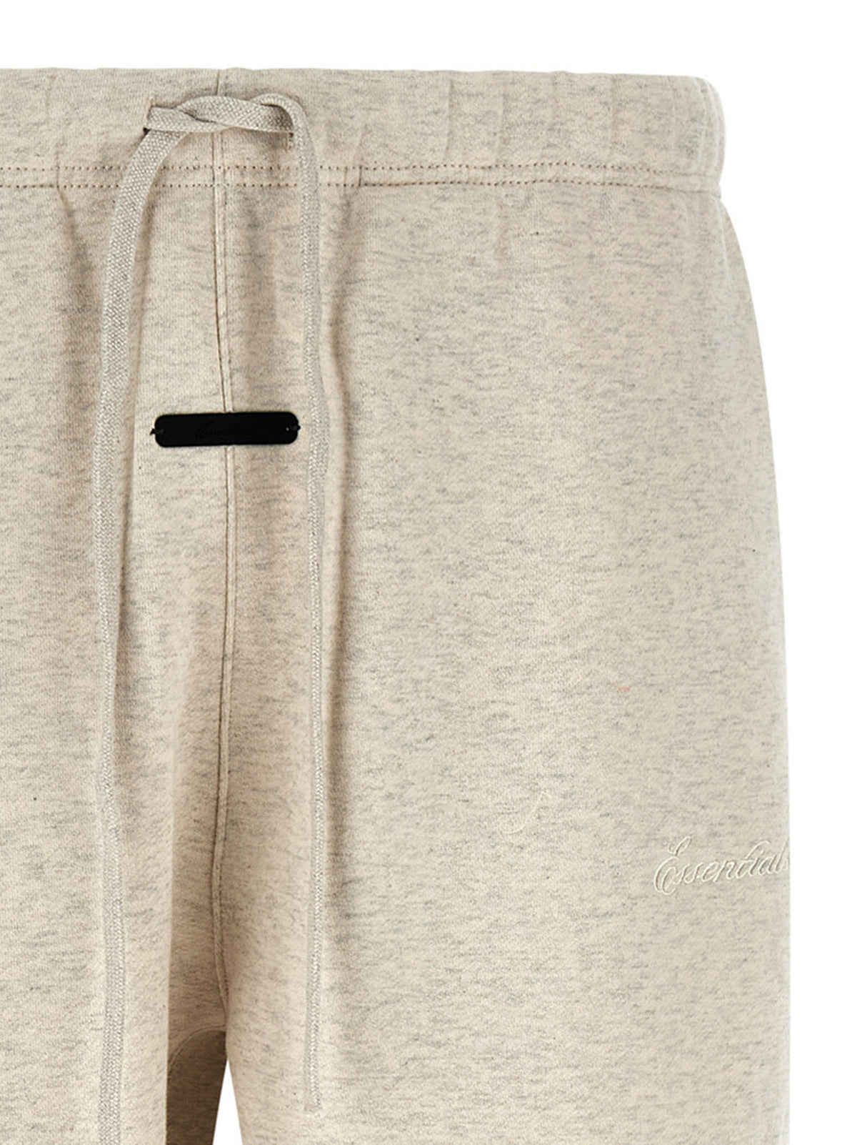 Detail van de elastische tailleband met lange koorden en het zwarte label midden voor