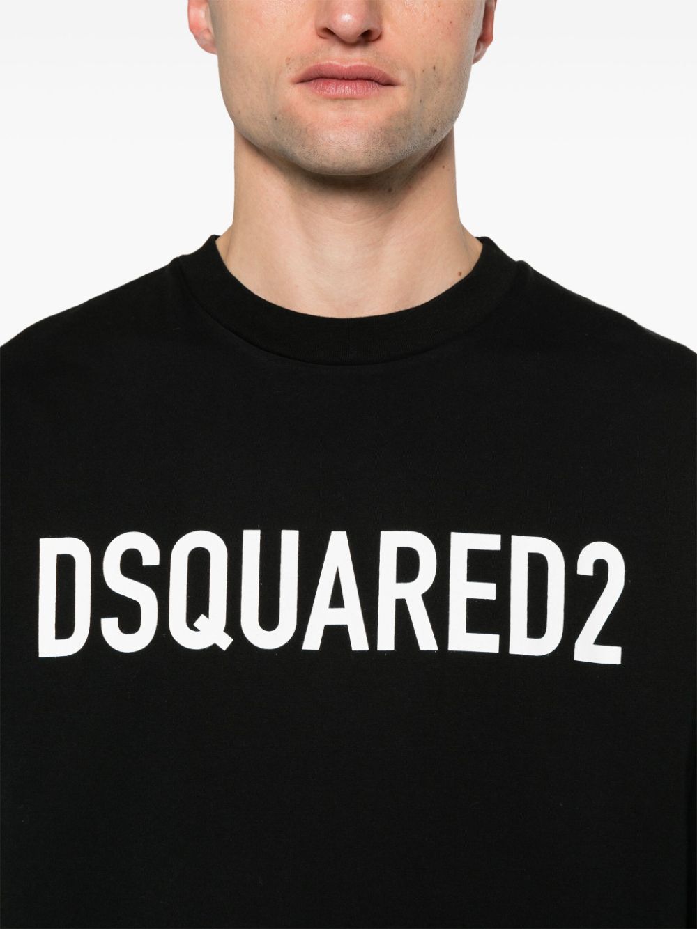 Detail van de witte DSQUARED2-letters en de geribde ronde hals