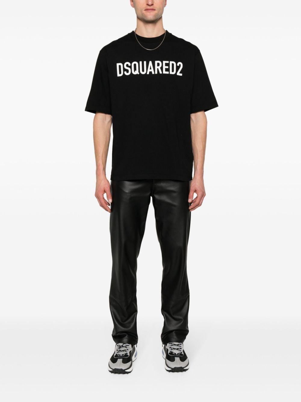 Model draagt het zwarte Dsquared2 logo T-shirt bij een zwarte leren broek