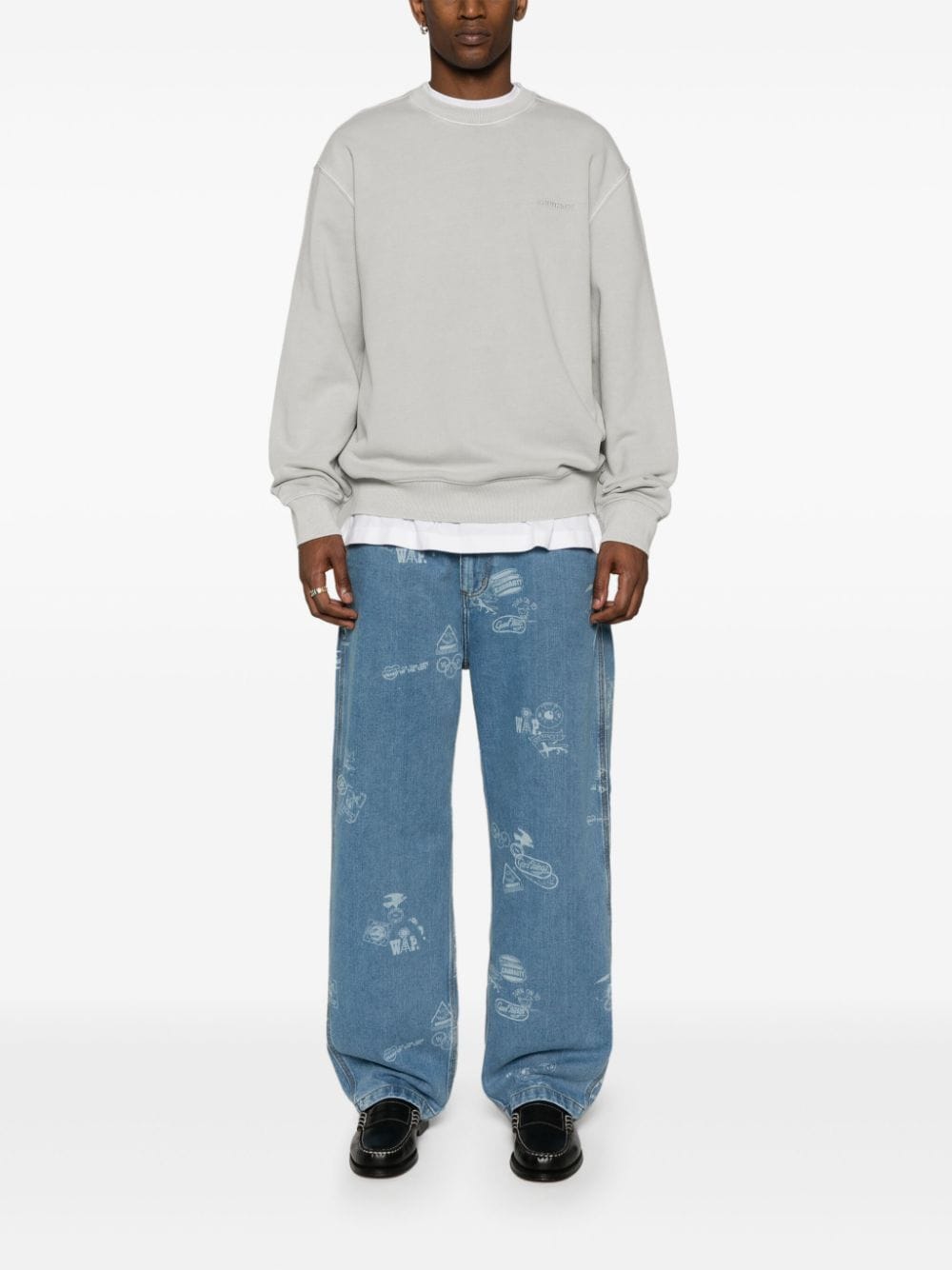 Model draagt de grijze Carhartt WIP Duster Script sweater bij een lichtblauwe jeans
