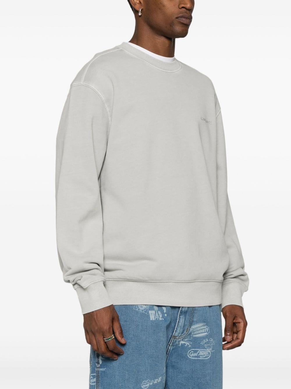 Carhartt WIP Duster Script sweater op model, met geribde manchetten en verlaagde schoudernaad