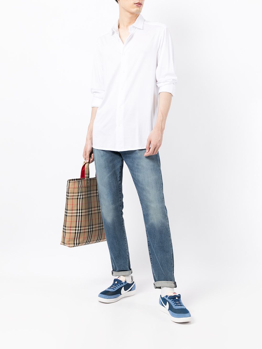 Volledig beeld van het witte Emporio Armani overhemd met opgerolde mouwen bij een jeans