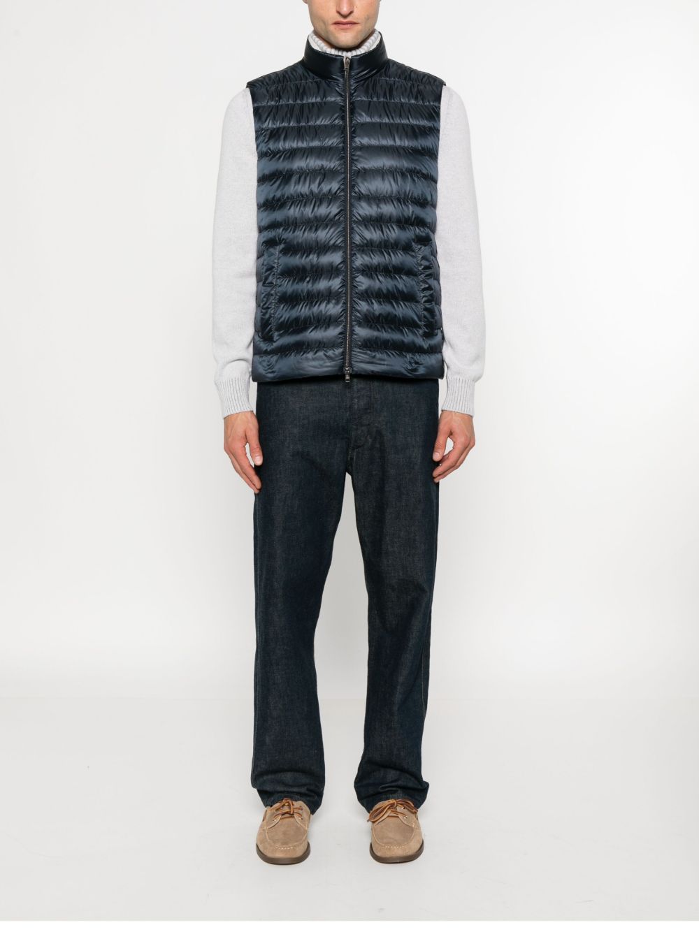 Model draagt het navy Herno donsgilet over een grijze trui met donkere jeans