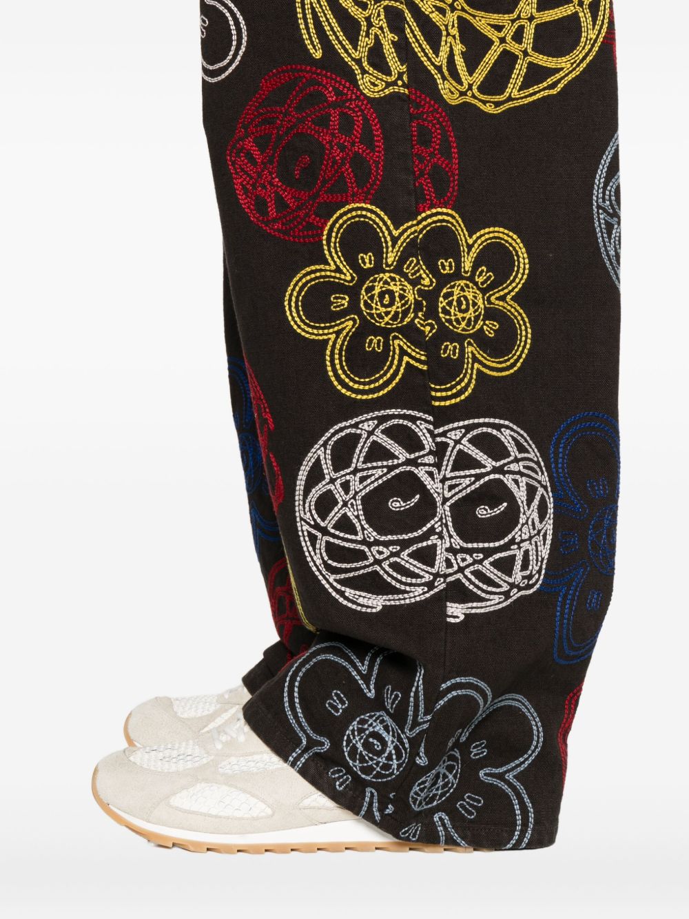Detail van het meerkleurige borduurwerk op de bruine katoenen Kenzo x Futura 2000 broek