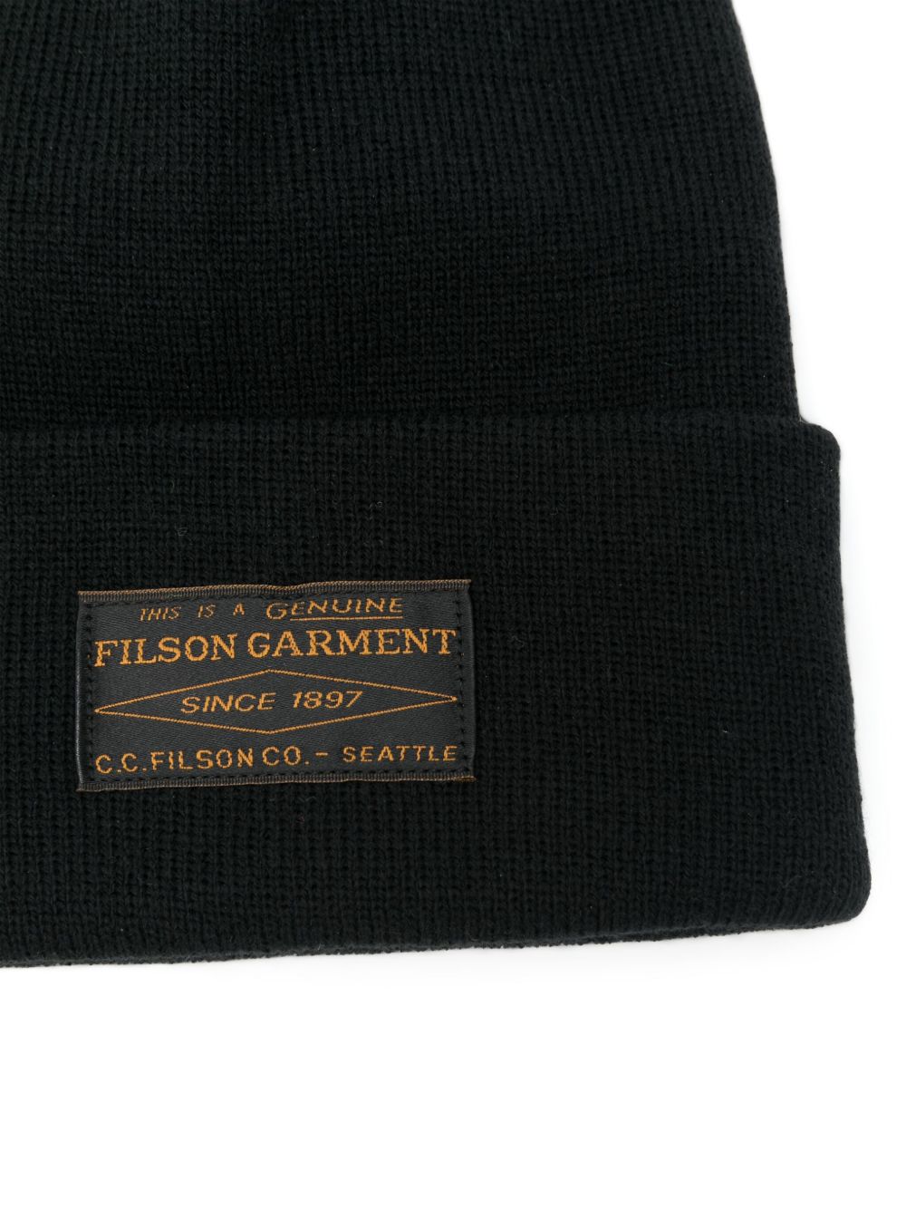 Close-up van het geweven label met SINCE 1897 en C.C. Filson Co. Seattle