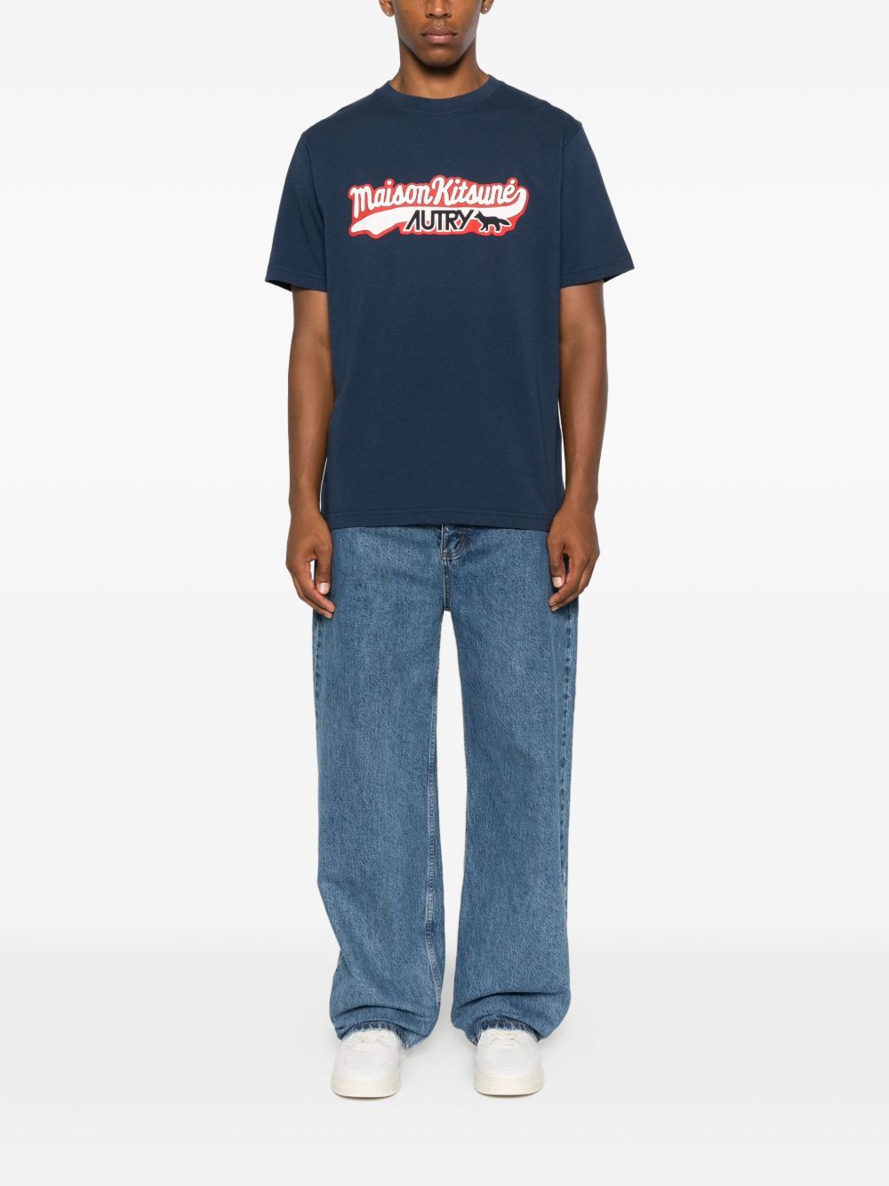Model draagt het donkerblauwe T-shirt op een lichte jeans