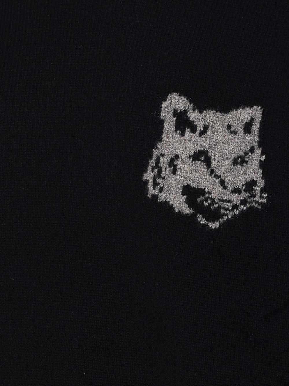 Close-up van het intarsia vossenhoofd waarin de grijze steken zichtbaar overgaan in het zwart