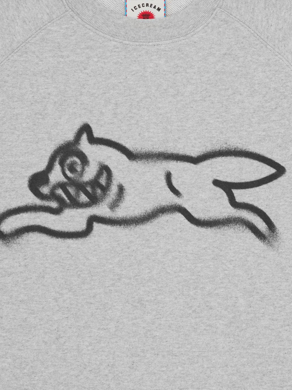 Close-up van de spraypaint Running Dog-print met nevelige randen op grijs katoen