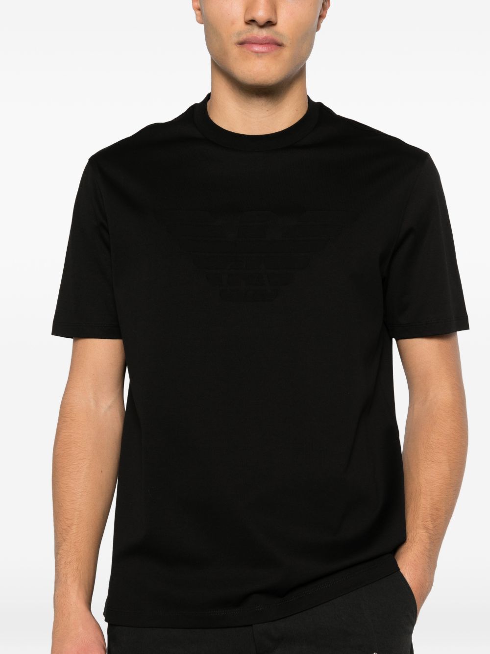 Model draagt het zwarte Emporio Armani T-shirt, vooraanzicht met ronde hals