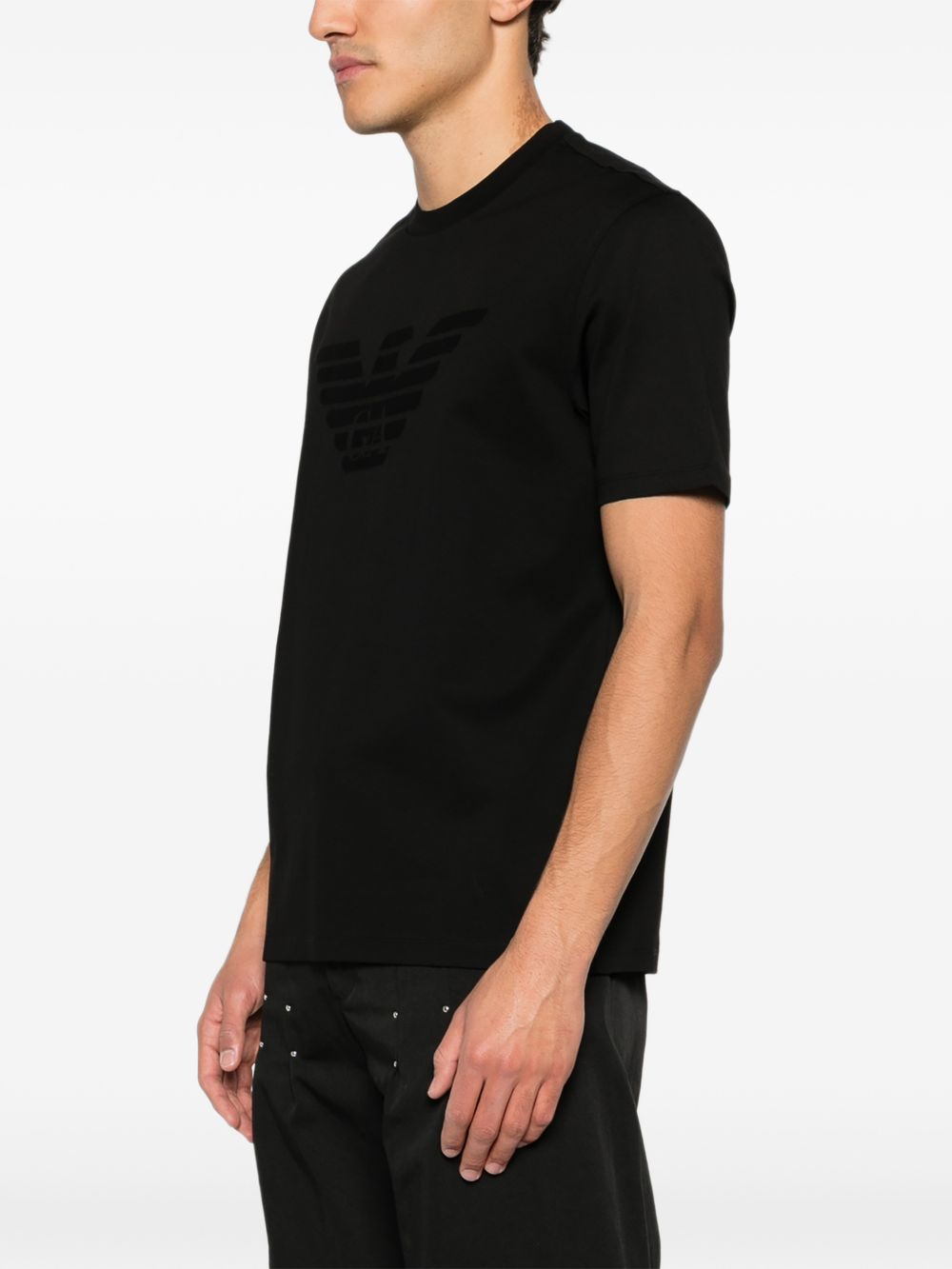 Detail van de grote matte adelaar op de borst van het zwarte Emporio Armani T-shirt