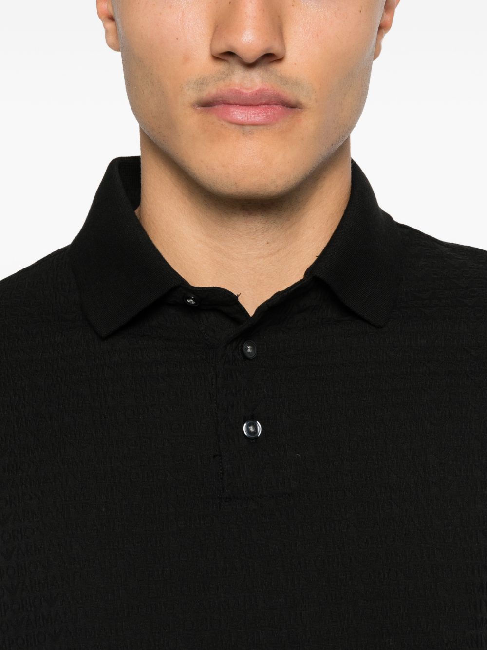 Emporio Armani poloshirt zwart, close-up van kraag, knopen en het geweven logopatroon