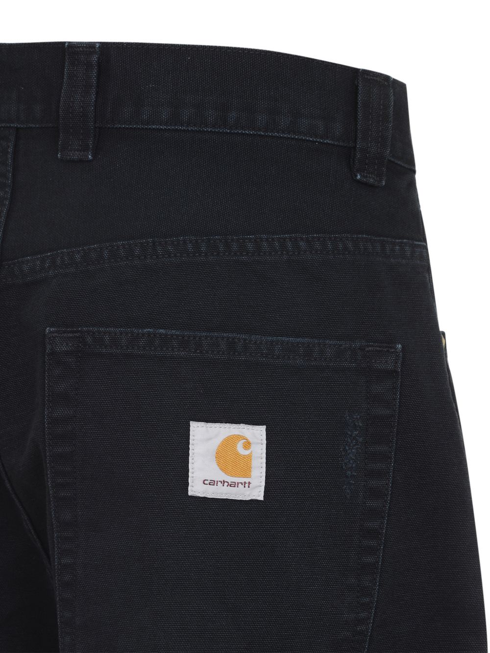 Close-up van de achterzak met geweven Carhartt Square Label en klinknagel