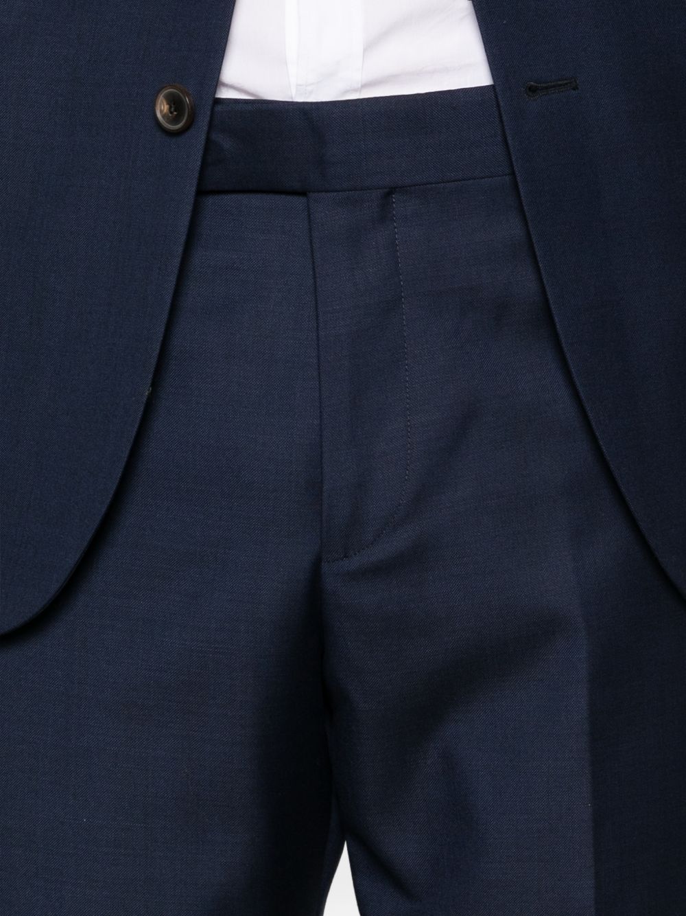 Detail van de pantalon met vlakke voorkant, riemlussen en ingeperste vouw
