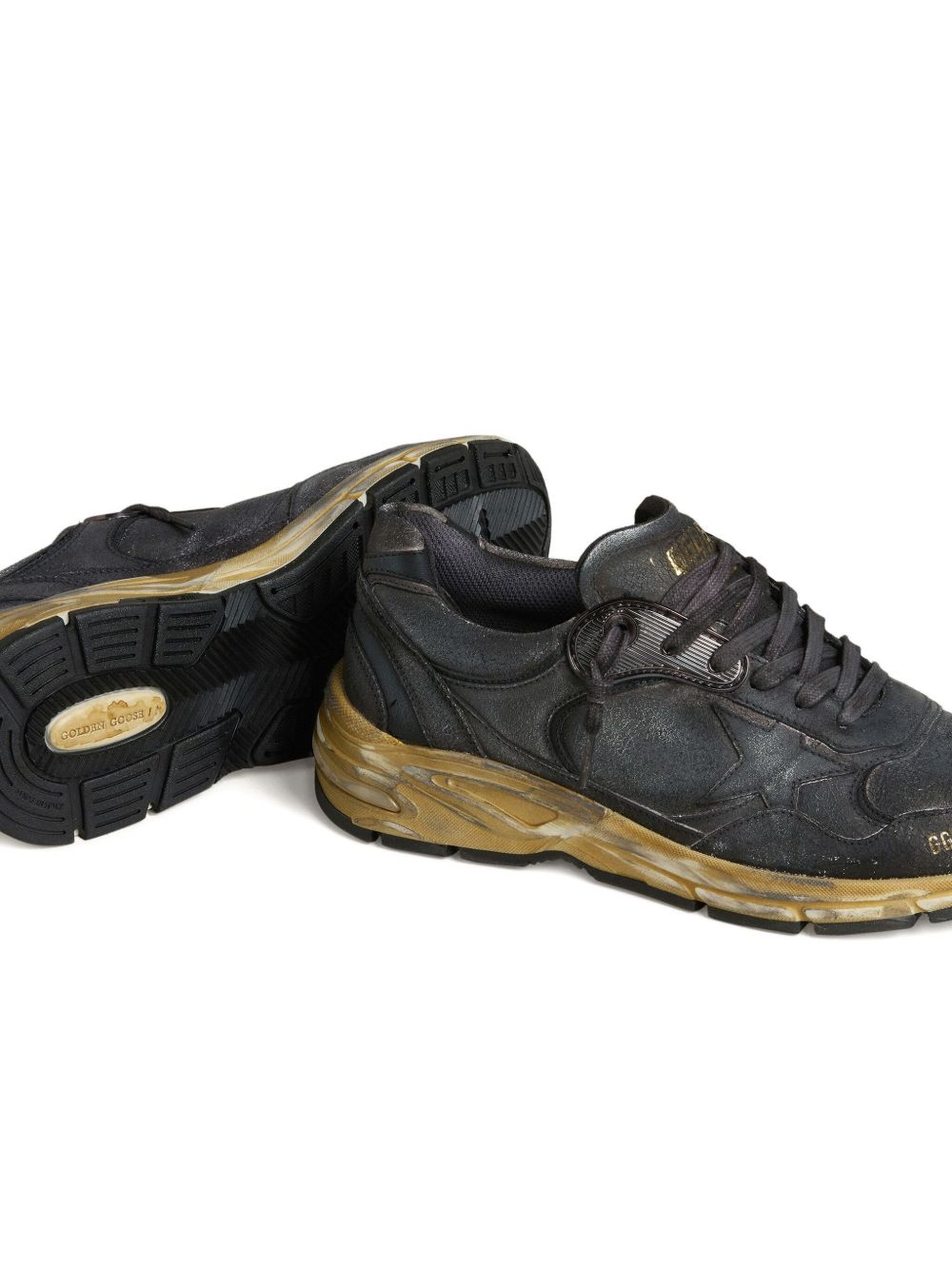 Twee Dad-Star sneakers waarvan er één op de zijkant ligt en het rubberen loopvlak toont