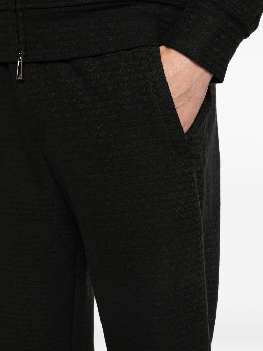 Model draagt de zwarte Emporio Armani jogger, vooraanzicht met toelopende pijpen