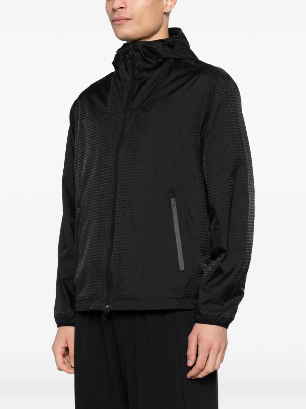 Model draagt de zwarte Emporio Armani blouson open over een zwarte broek