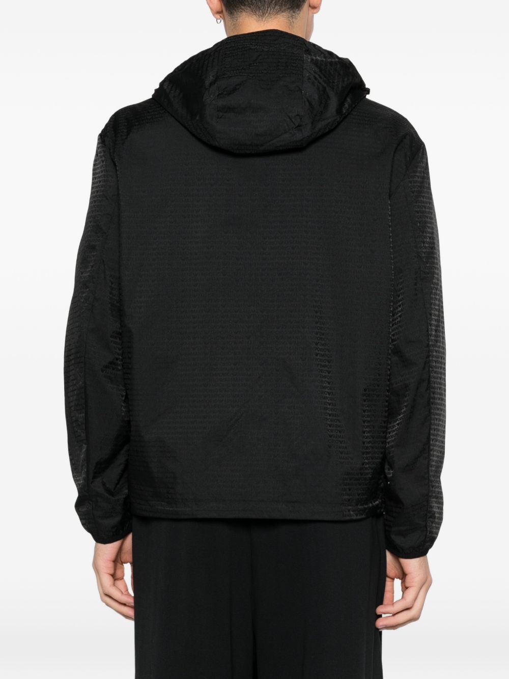 Achterkant van de zwarte blouson met capuchon, gedragen door het model