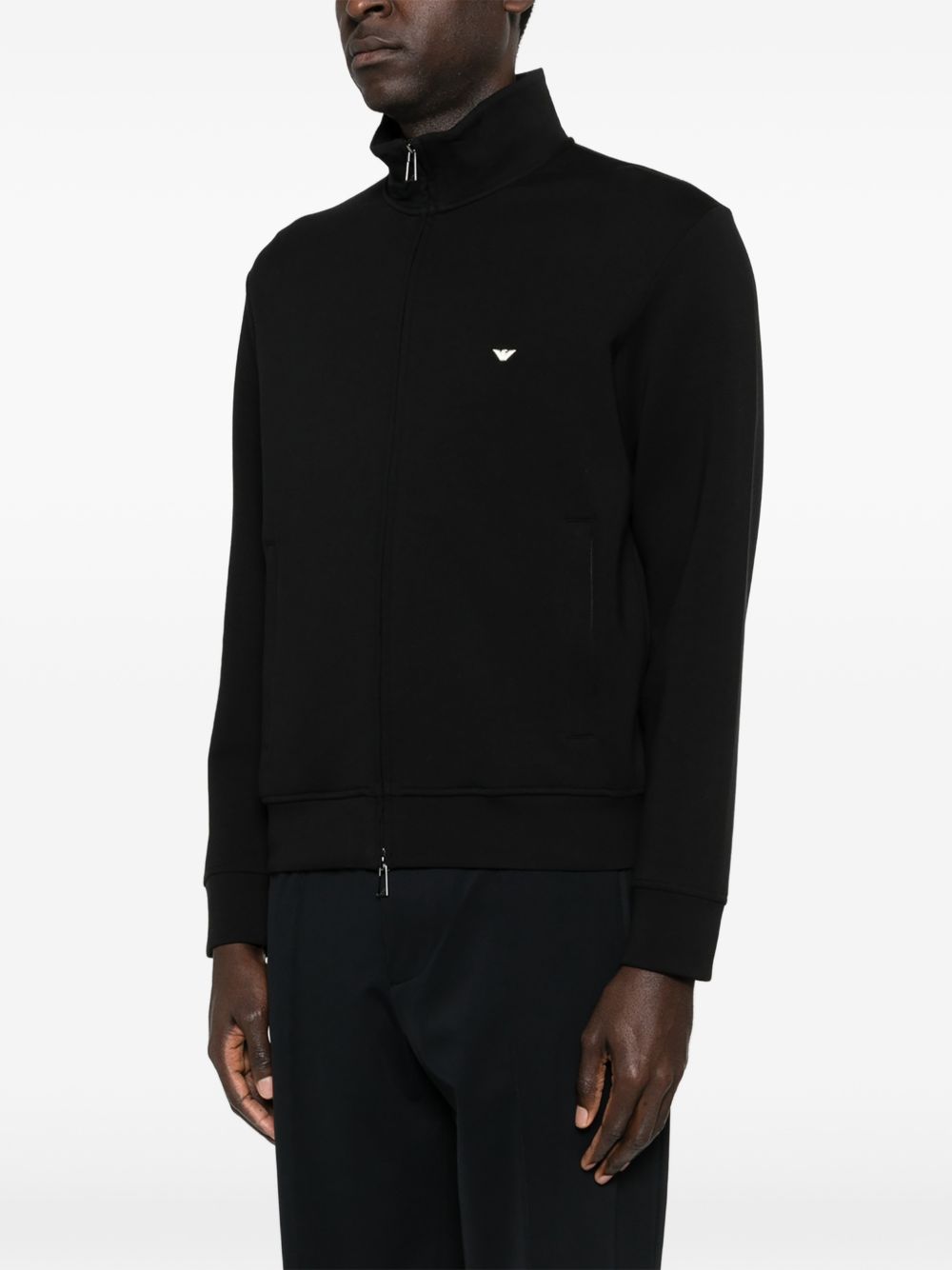 Detail van de zijzak met rits en de geribde zoom van de sweater