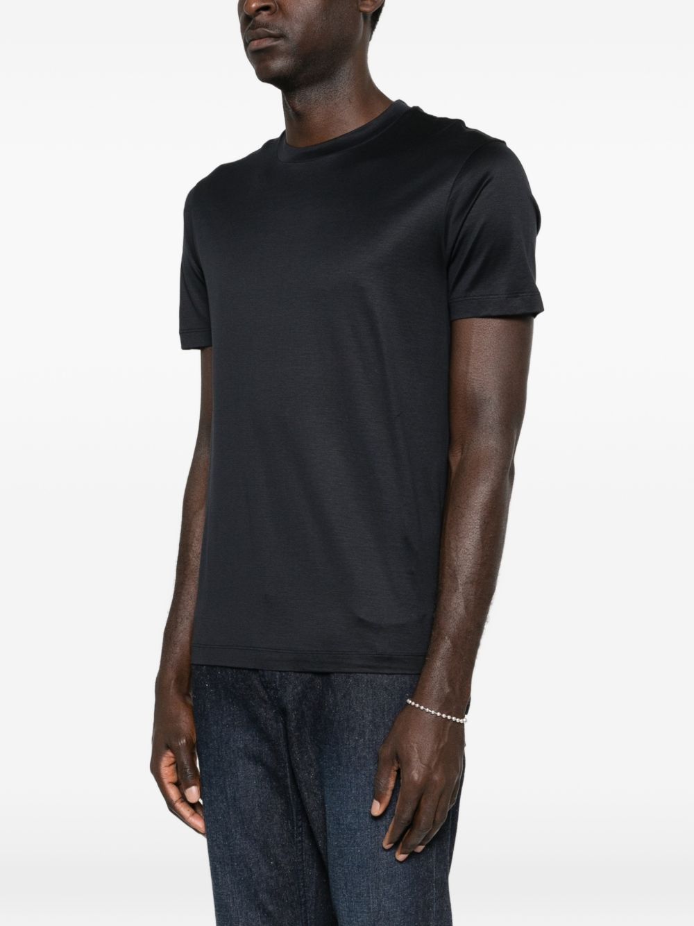 Emporio Armani donkerblauwe lyocell-katoen T-shirt, close-up van het tonale logo aan de zoom
