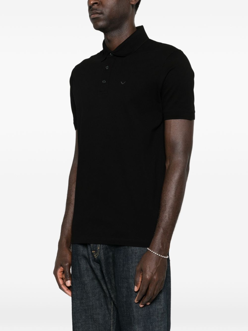 Zijaanzicht van de zwarte Emporio Armani polo