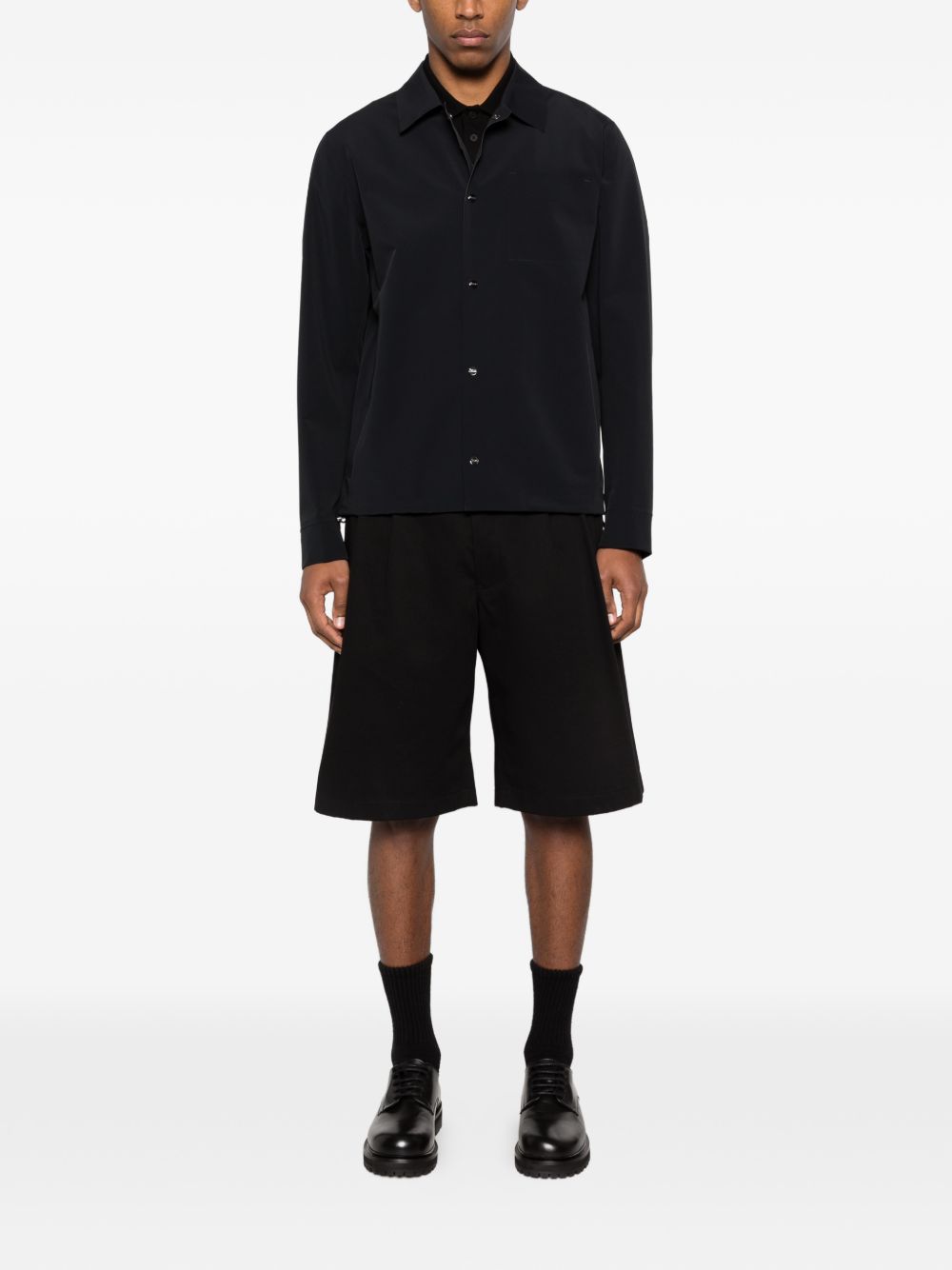 Model draagt het zwarte overshirt met een korte broek