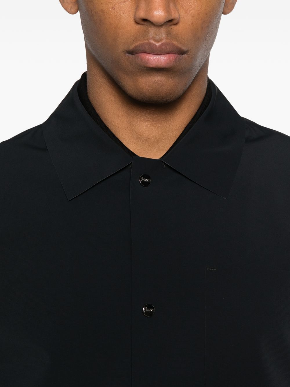 Detail van de kraag met het metalen Herno-plaatje