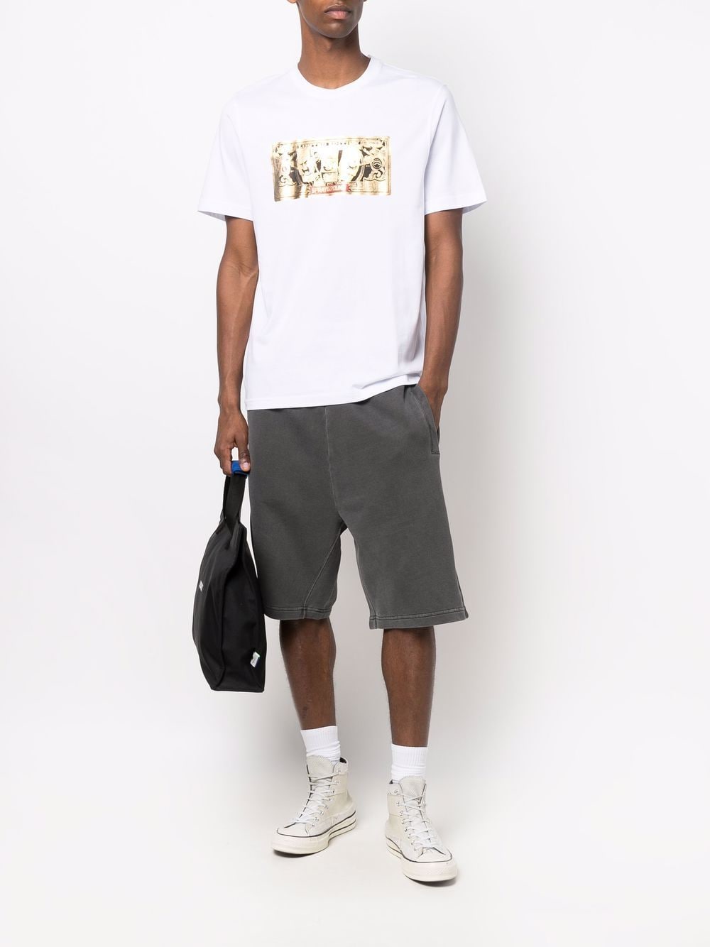 Model draagt de zwarte Nelson Sweat Short bij een wit T-shirt en hoge sneakers