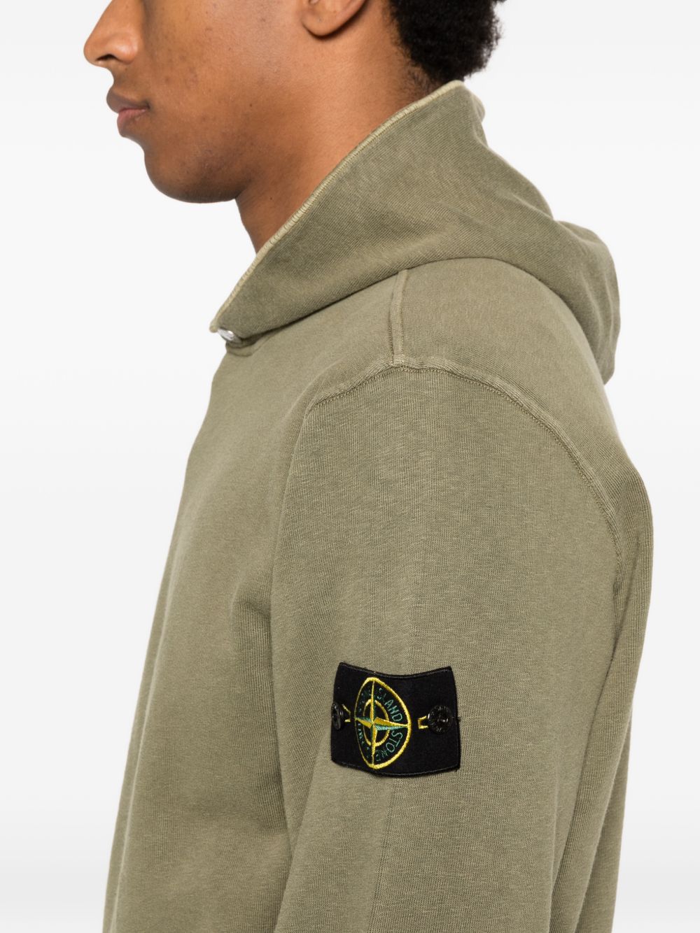 Detail van de afneembare kompasbadge op de linkermouw van de hoodie