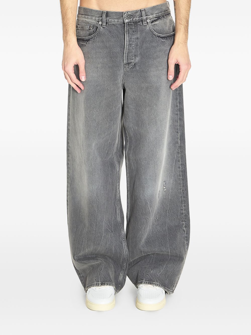 Vooraanzicht van de brede grijze jeans met slijtlijnen op de dijen