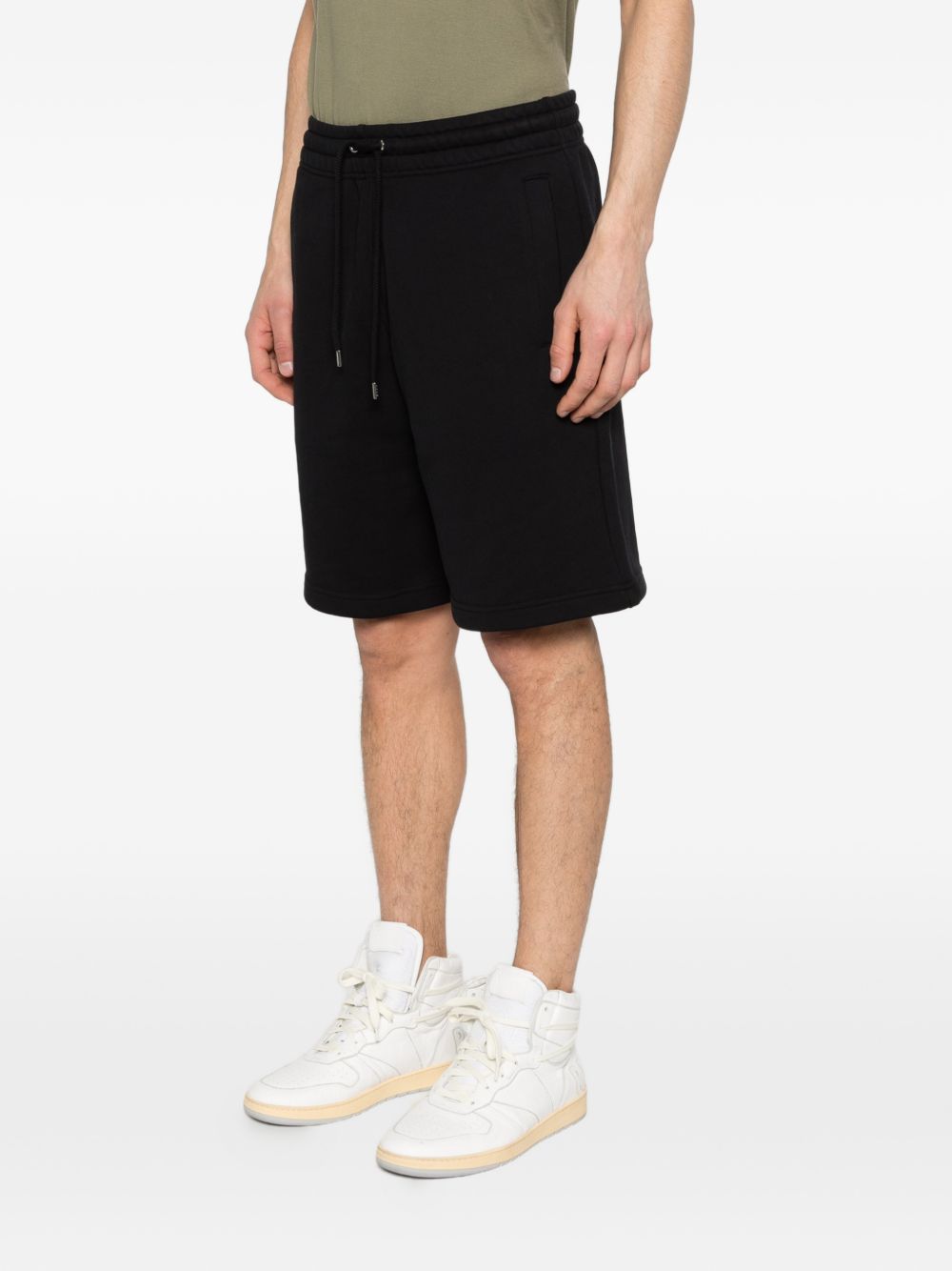 Detail van het witte Maison Kitsuné Paris-borduursel op de short
