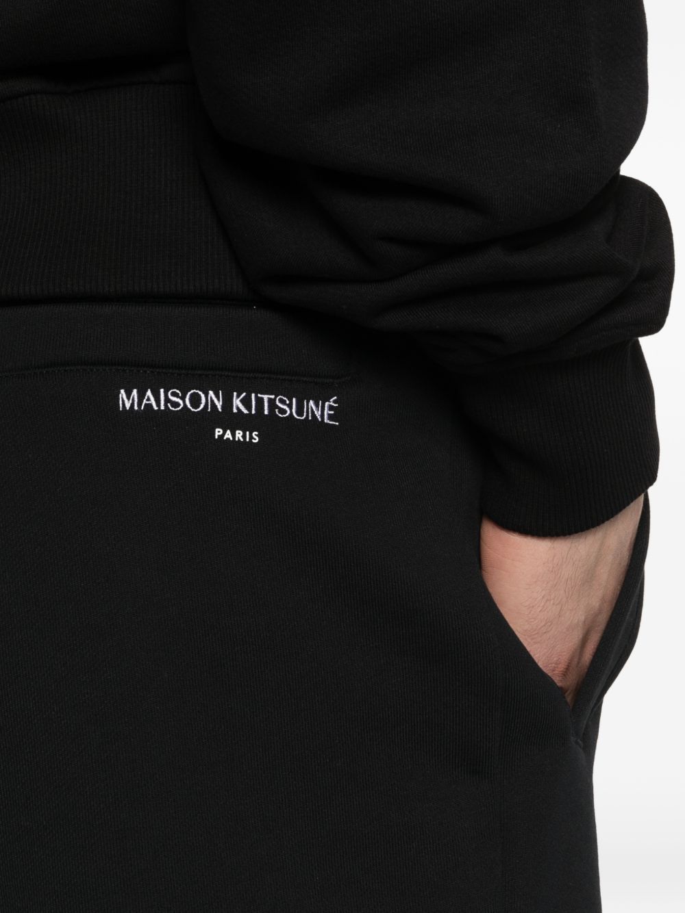 Zwarte jog short gedragen bij een bijpassend vest, volledig beeld