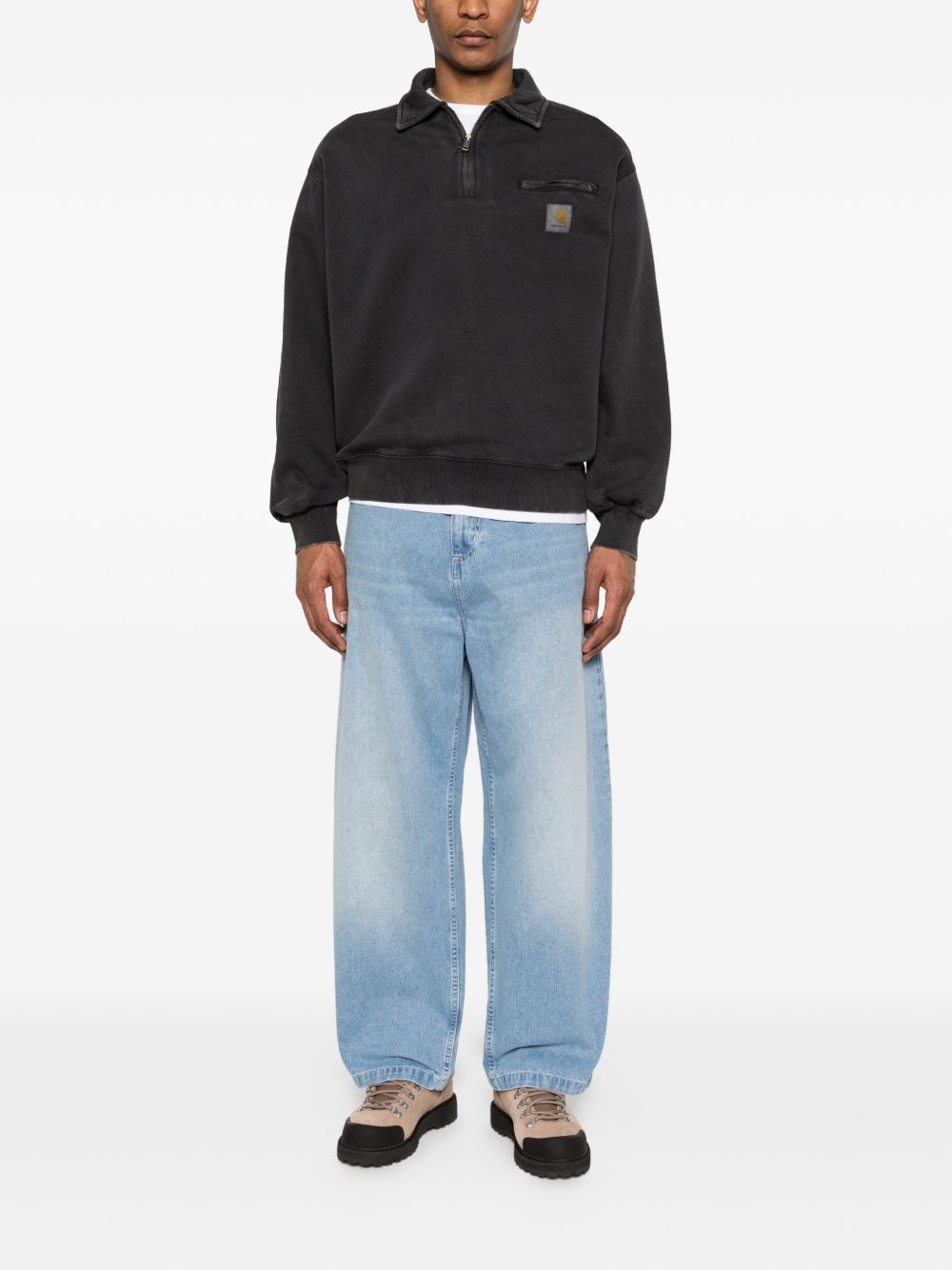 Zwarte Carhartt WIP half-zip sweater gecombineerd met een lichte jeans