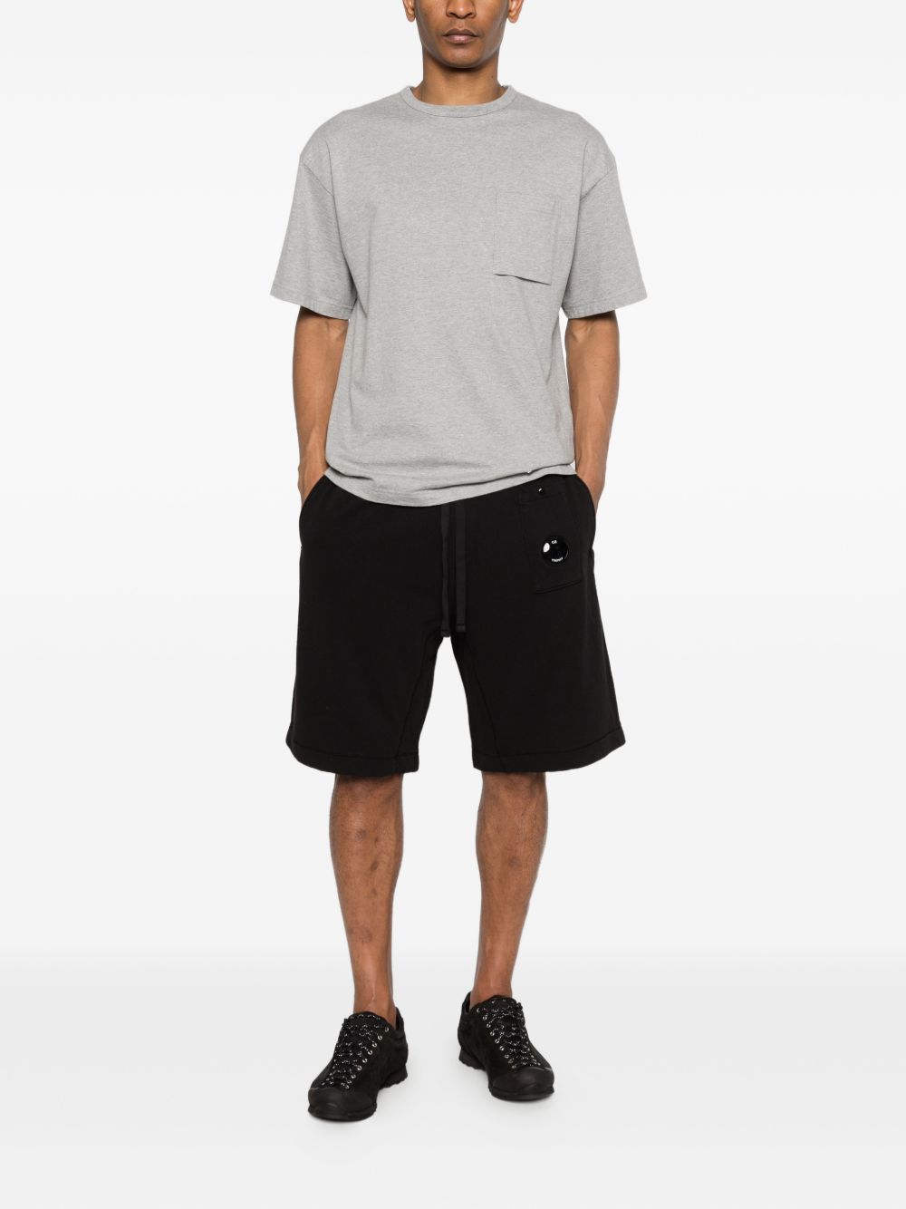 Zijaanzicht van de zwarte sweatshort gecombineerd met een grijs T-shirt
