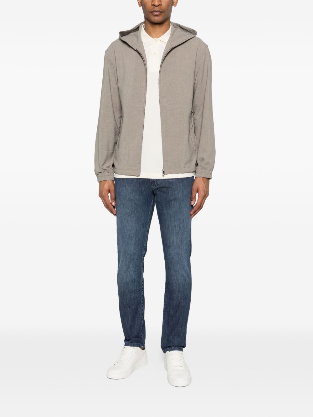 Vooraanzicht ten voeten uit van het Emporio Armani blouson met jeans