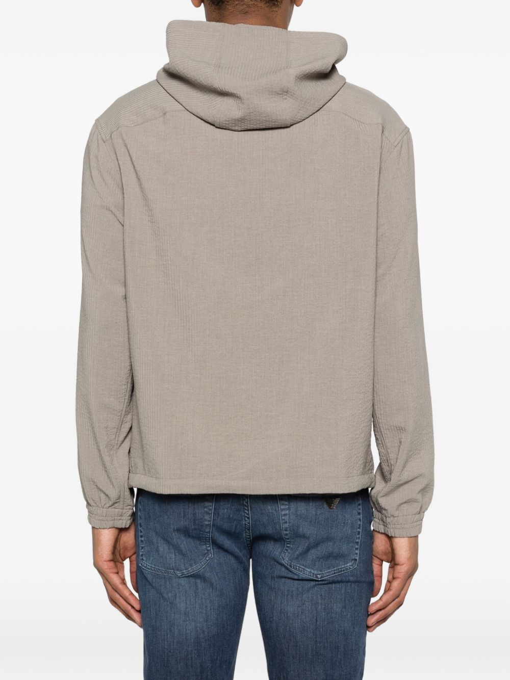Achteraanzicht van het beige blouson met capuchon en stretch manchetten