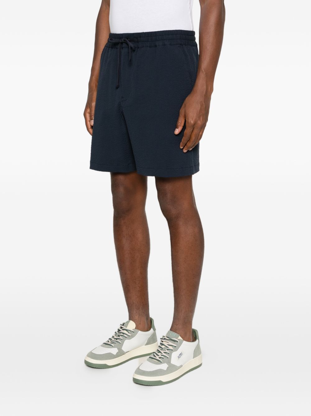 Marineblauwe Maison Kitsuné short op het model met zichtbaar geknoopt trekkoord