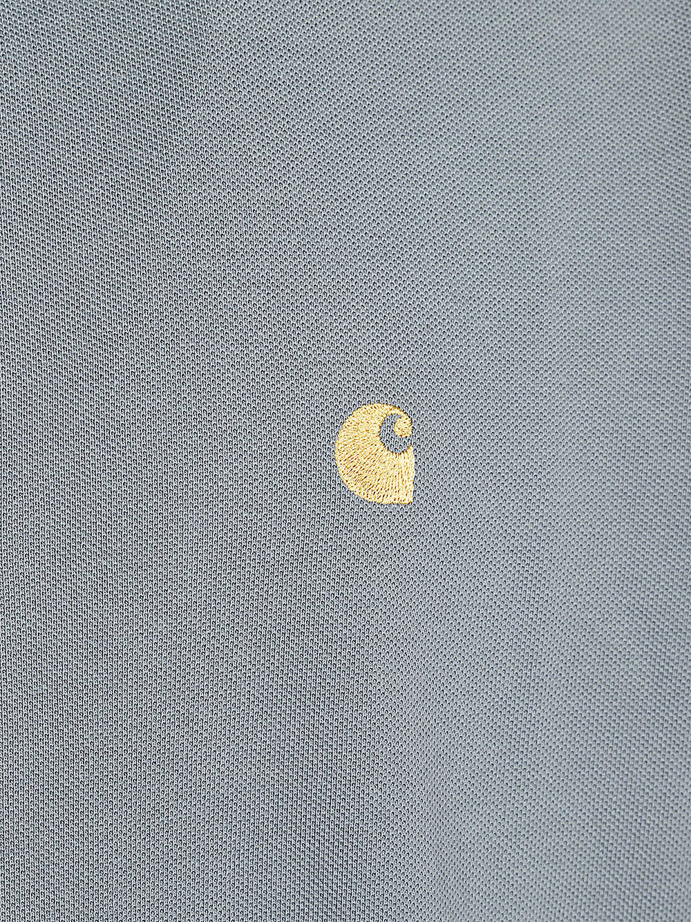 Close-up van het geborduurde Carhartt C-logo op de Chase Pique Polo in grijs