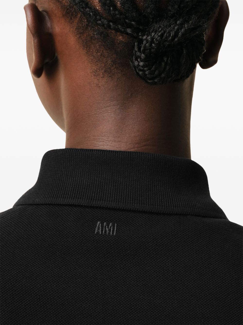 AMI Paris Ami de Cœur polo in zwart, close-up van de parelmoeren knopen