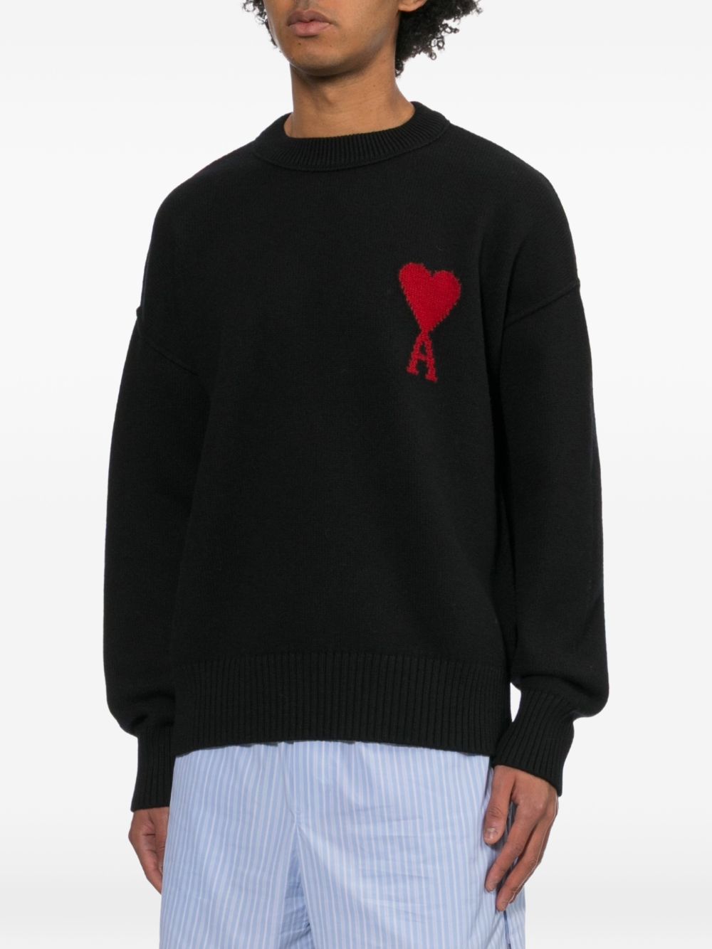AMI Paris Ami de Coeur trui gedragen door een model, gecombineerd met een gestreepte short