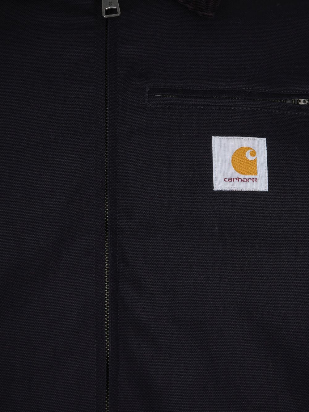 Carhartt WIP Detroit Jacket in zwart, detail van de rits-borstzak met geborduurd logo