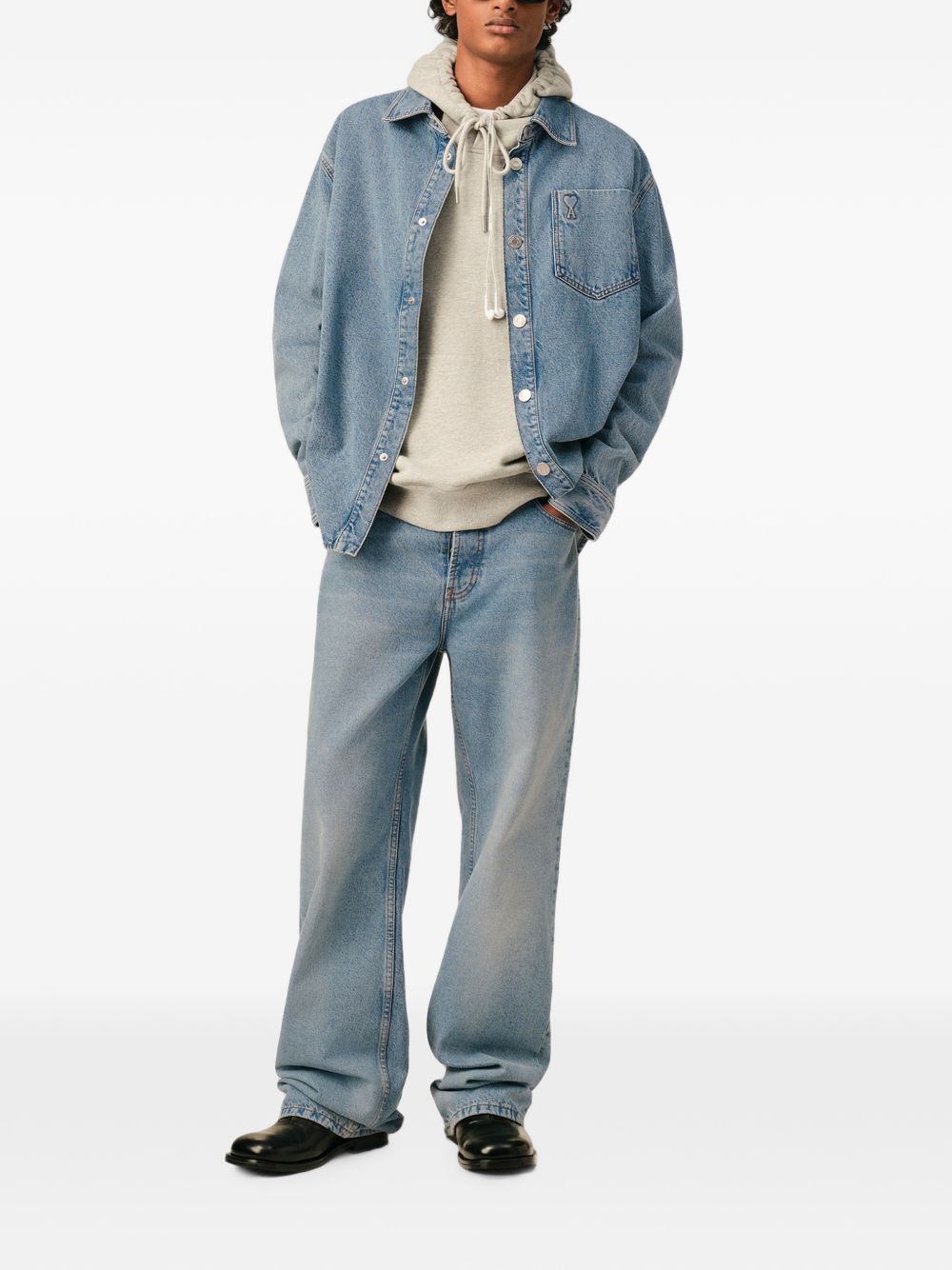 Model draagt het denim overshirt open over een lichte trui